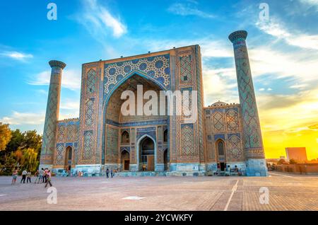 SAMARKAND, OUZBÉKISTAN - 28 août : Ulugh Beg madrasah du Reghistan dans le coucher du soleil avec des gens en face d'elle. Samarkand, Août 2016 Banque D'Images