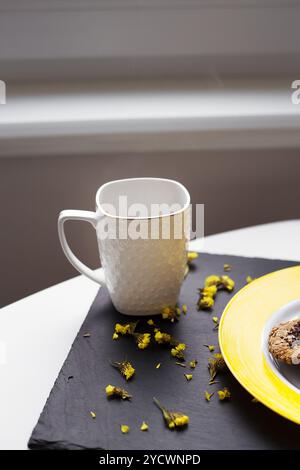 Oatmeal Cookies au chocolat sur la plaque jaune vif et tasse de café. Banque D'Images