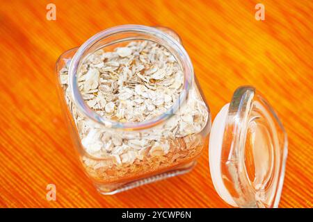 Flocons d'avoine dans un pot sur serviette orange. Banque D'Images