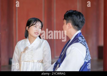 Un couple coréen, un homme de 30 ans et une femme de 20 ans, portent joyeusement Hanbok et sont assis dans un bâtiment historique à Séoul, en Corée du Sud. Banque D'Images