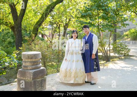 Un couple coréen, un homme de 30 ans et une femme de 20 ans, se promène harmonieusement dans un bâtiment historique à Séoul, en Corée du Sud, vêtu de Hanbok. Banque D'Images