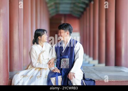 Un couple coréen, un homme de 30 ans et une femme de 20 ans, portent joyeusement Hanbok et sont assis dans un bâtiment historique à Séoul, en Corée du Sud. Banque D'Images