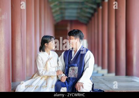 Un couple coréen, un homme de 30 ans et une femme de 20 ans, portent joyeusement Hanbok et sont assis dans un bâtiment historique à Séoul, en Corée du Sud. Banque D'Images