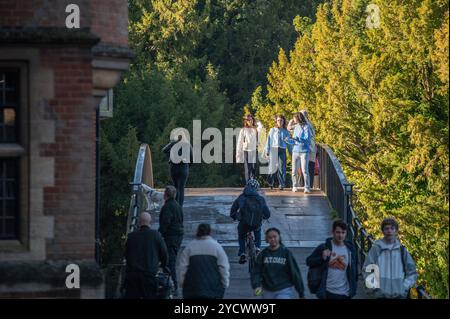 Cambridge, Royaume-Uni. 24 octobre 2024. Les membres du public traversent un pont à Cambridge sous le soleil du matin. Le met Office a prévu une journée sèche et surtout ensoleillée avec des températures douces et des vents bleus occasionnels dans l'est de l'Angleterre. Crédit : David Tramontan / Alamy Live News Banque D'Images