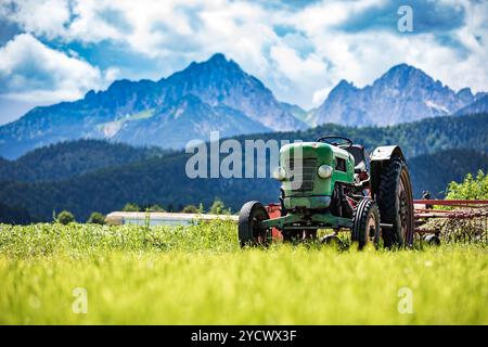 Vieux tracteur dans les prairies alpines Banque D'Images