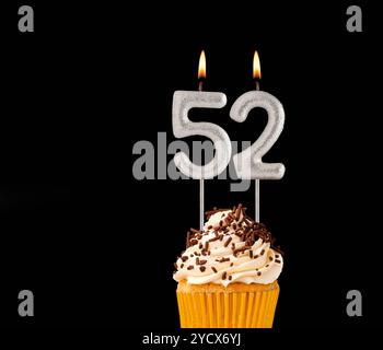 Numéro 52 bougies en forme - cupcake d'anniversaire sur fond noir. Banque D'Images