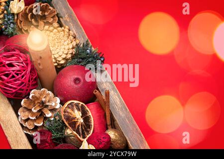 Boîte de Noël antique remplie de pot-pourri sur un fond rouge vif avec effet boken. Banque D'Images