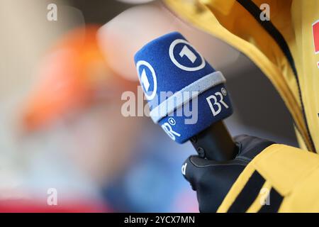 Nuremberg, Allemagne. 24 octobre 2024. Habillage des athlètes de la DSV (Association allemande de ski) dans le MesseCongressCentrum. Un athlète tient un micro de ARD et BR (Bayerischer Rundfunk). Crédit : Daniel Löb/dpa/Alamy Live News Banque D'Images