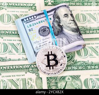 Bitcoin argent de crypto-monnaie et dollars américains pliés sur des billets de banque en dollars, gros plan Banque D'Images