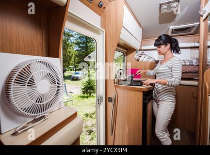 Femme cuisinant dans le camping-car, intérieur de camping-car RV Banque D'Images