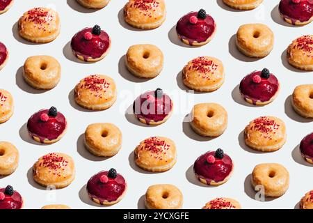 Un motif de beignets végétaliens avec des variétés classiques glacées, fourrées de cheesecake et fourrées de crème de fraise, chaque beignet est surmonté de glaçures brillantes, Banque D'Images