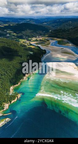 Superbe photographie par drone du littoral de la Galice, accentuant les eaux turquoises, les forêts verdoyantes et les estuaires pittoresques de la rivière ciel nuageux crée un Banque D'Images