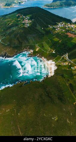 Captivant tir par drone mettant en valeur la côte accidentée de la Galice, avec ses eaux turquoises vibrantes, ses plages de sable et ses zones densément boisées Banque D'Images