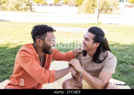 Couple gay, profitant d'une journée ensoleillée en plein air dans un parc de la ville les deux hommes, montrent de la chaleur et de l'affection, symbolisant diverses relations LGBTQIA+ Banque D'Images