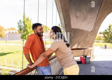 Un couple gay aimant partage un moment ludique dans un parc urbain, mettant en valeur leur bonheur et la force de leur relation cette image capture th Banque D'Images