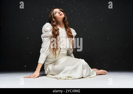 Une jeune femme époustouflante regarde vers le haut, ses longs cheveux en cascade autour d'elle, entourée d'étincelles. Banque D'Images