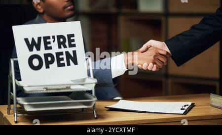 Gros plan d'une poignée de main ferme entre deux collègues, symbolisant la confiance et la réussite de l'affaire. Banque D'Images