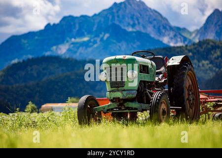 Vieux tracteur dans les prairies alpines Banque D'Images