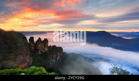 Lever de soleil sensationnel avec des nuages texturés et un brouillard dense rare dans la Jamison Valley légèrement coloré avec le ciel du lever du soleil. Vues sur la reine Elizabeth Banque D'Images