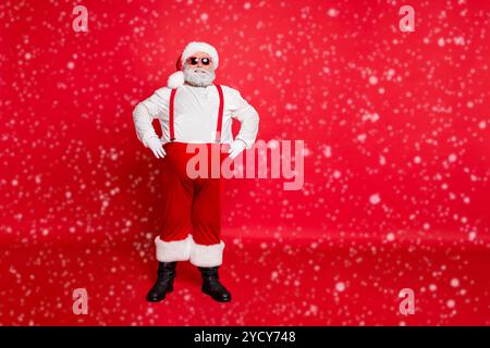 Photo du corps entier de positif drôle gras en surpoids père noël avec des lunettes de style grand ventre prêt à célébrer la fête de nouvel an debout isolé sur Banque D'Images