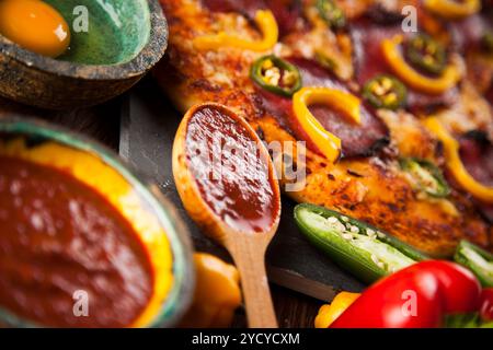 Pizza savoureuse, de tomates et d'autres ingrédients sur un fond de bois Banque D'Images