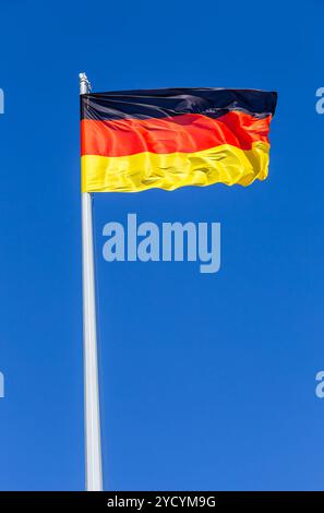 Pavillon de l'Allemagne au vent contre le ciel bleu Banque D'Images