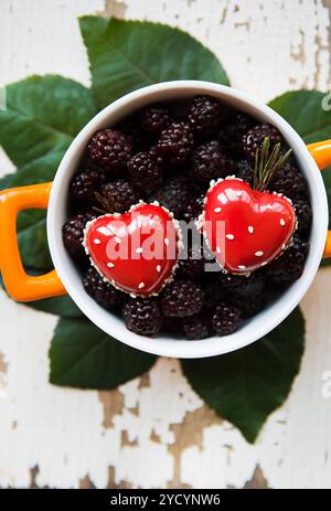 Une totalité de l'assiette avec un dessert en forme de coeur se dresse sur un vieux fond de bois Banque D'Images