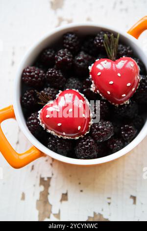 Un blackboy plaque avec un dessert sous la forme d'un cœur se dresse sur un fond de bois, close-up Banque D'Images