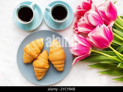 Deux tasses de café, des croissants et un bouquet de tulipes roses, belle matinée Banque D'Images