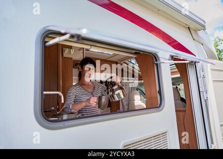 Femme cuisinant dans le camping-car, intérieur de camping-car Banque D'Images