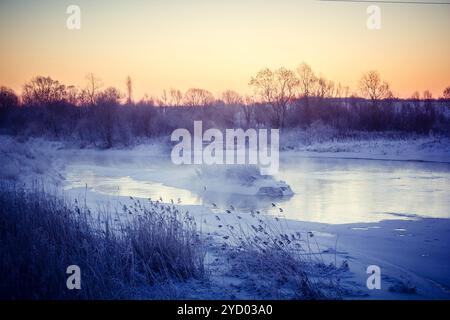 Aube sur la rivière USVA, Russie. Matin glacial sur la rivière, hiver. Neige sur les rives de la rivière, forêt dense Banque D'Images