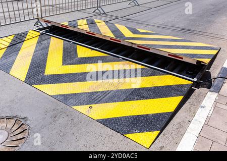 Barrière routière avec motif d'avertissement rayé jaune et noir Banque D'Images