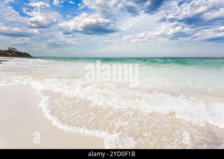 Les vagues se jettent à terre sur la magnifique plage de Hyams Beach tandis que de jolis nuages flottent dans le ciel au-dessus. Côte sud Shoalhaven Australie Banque D'Images