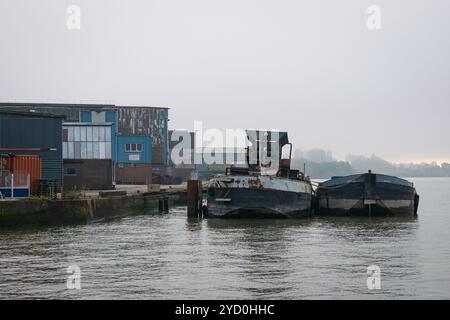 Les vieux bateaux sont amarrés dans le port de Rotterdam avec des conteneurs sur le quai Banque D'Images