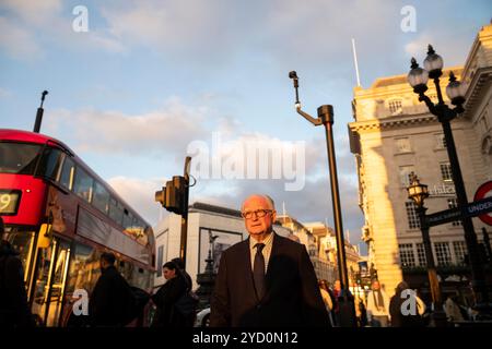 Un ouvrier municipal mûr habillé en costume et cravate marche le long de Piccadilly dans le West End de Londres, en Angleterre, au Royaume-Uni Banque D'Images