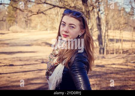 La jeune fille aux cheveux blonds des promenades dans le parc au printemps. Une fille aux cheveux blonds. Jeune fille belle et mince Banque D'Images