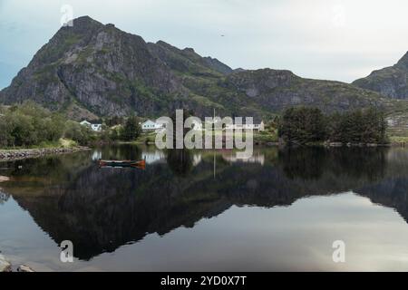 Une vue sereine sur les îles Lofoten offre des eaux calmes reflétant les montagnes escarpées et la verdure. Cet endroit pittoresque invite à l'exploration et Banque D'Images