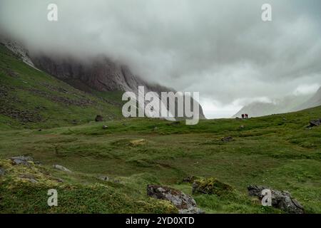 Explorez la plage enchanteresse de Bunes Beach dans les Lofoten, où la randonnée au milieu de prairies luxuriantes révèle un panorama captivant entouré de brouillard et d'un spectaculaire mountai Banque D'Images