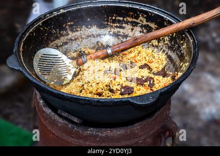 Cuisson du pilaf ouzbek traditionnel dans un grand chaudron Banque D'Images