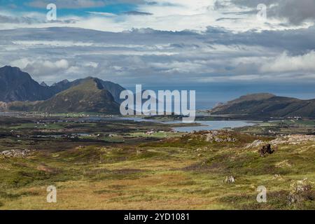 Une vue imprenable capture le vaste paysage des îles Lofoten dans le comté de Nordland, en Norvège. Collines ondulantes rencontrent l'océan, encadrées par des m majestueux Banque D'Images