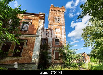 Vieux bâtiment en briques abandonné en été Banque D'Images