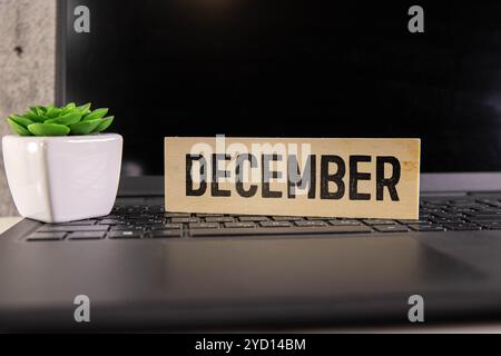 Symbole de décembre. Mot conceptuel décembre sur des blocs de bois sur beau fond brun, pose plate, espace de copie. Banque D'Images