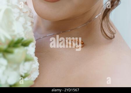 Moment de mariage romantique : gros plan sur les anneaux de mariage et le bouquet. Banque D'Images