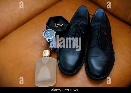 Arrangement d'accessoires sophistiqués pour hommes sur canapé en cuir. Banque D'Images