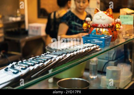 Taipei, Taiwan - 10 octobre 2019 : découverte de la cuisine locale dans un marché nocturne animé de Taipei, Taiwan avec une statue de chat accueillante Banque D'Images