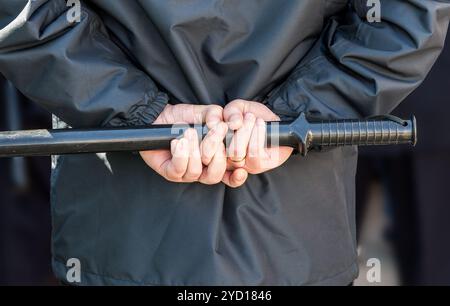 Matraque de police entre les mains d'un policier Banque D'Images