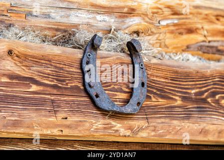 Old rusty horseshoe accroché au mur Banque D'Images