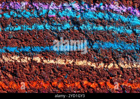 Mur texturé présentant une variété de couleurs vives et de motifs. Riche palette de couleurs sur le trottoir Banque D'Images