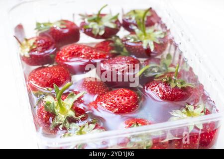 Fraises dans un bol d'eau. Baies rouges. Baies de saison dans l'eau. Banque D'Images