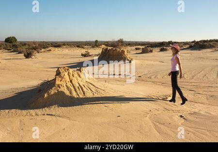 Une femme marche dans un paysage désertique de l'outback australien Banque D'Images